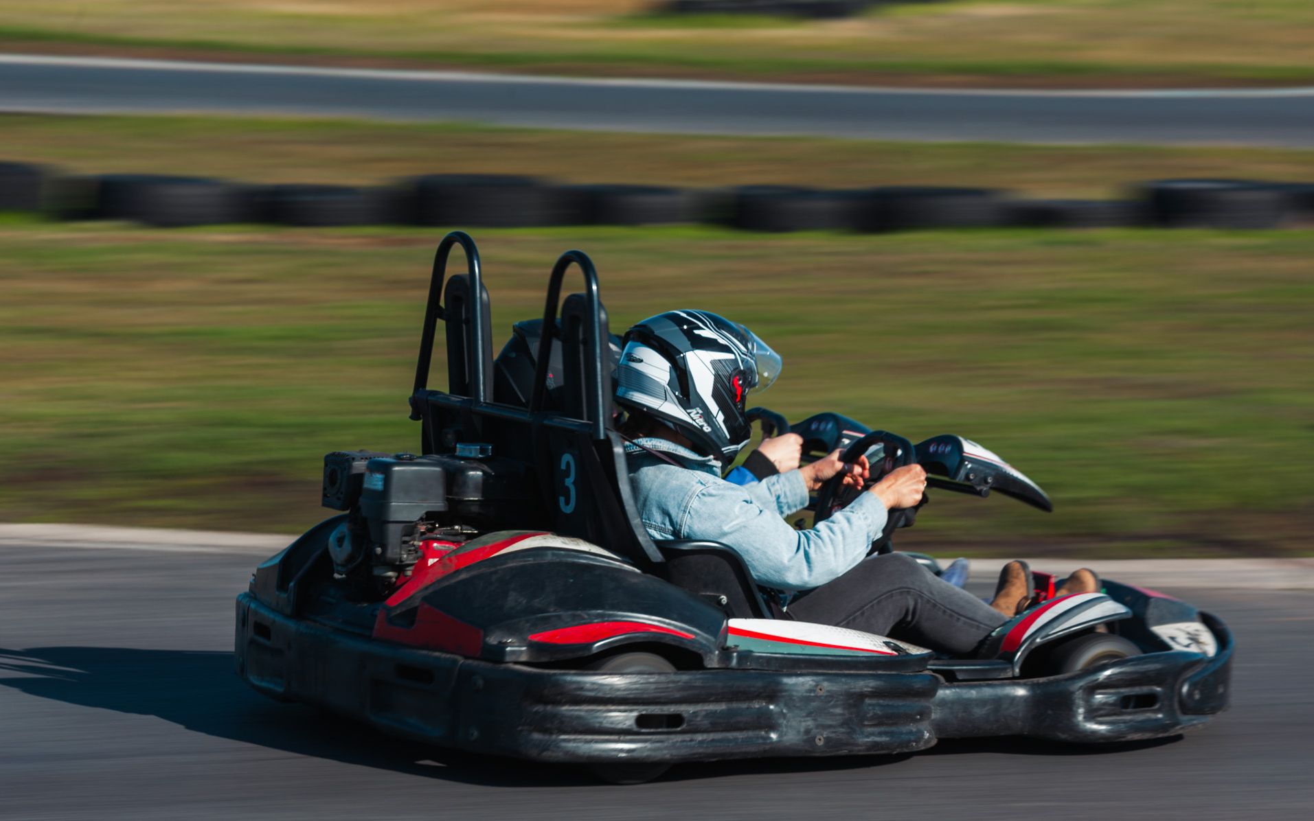A driver and passenger in a Sodi 2-Drive kart at speed